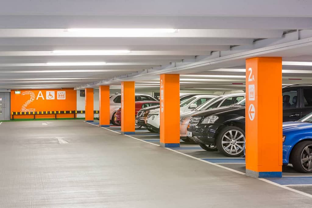 View through level 2 A of Boar Lane car park in Leeds, with large level identification orange colour coding on the lift wall and columns
