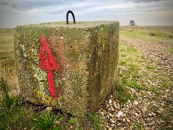 Example of low tech wayfinding design - arrow painted on a block at Orford Ness