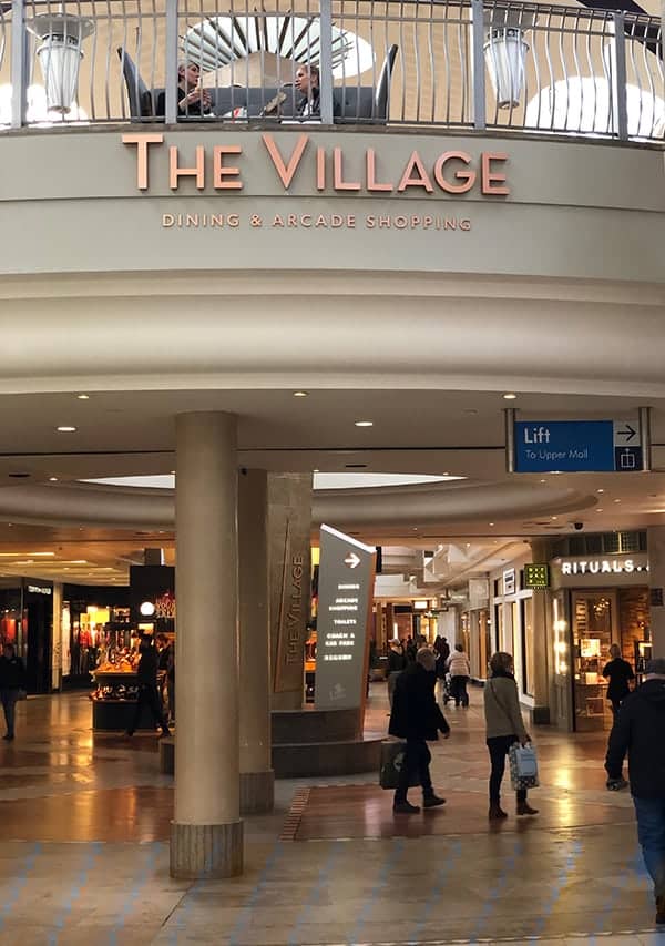 Entrance to The Village Arcade with the high level identification sign and totem at ground level
