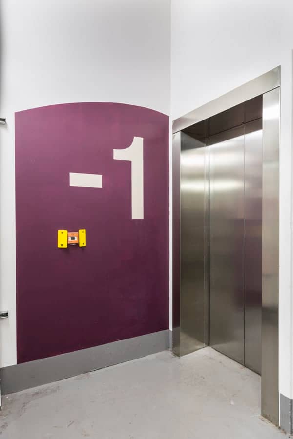 Large level -1 identification sign painted directly onto the wall in the lift lobby in the basement of 20 Fenchurch St