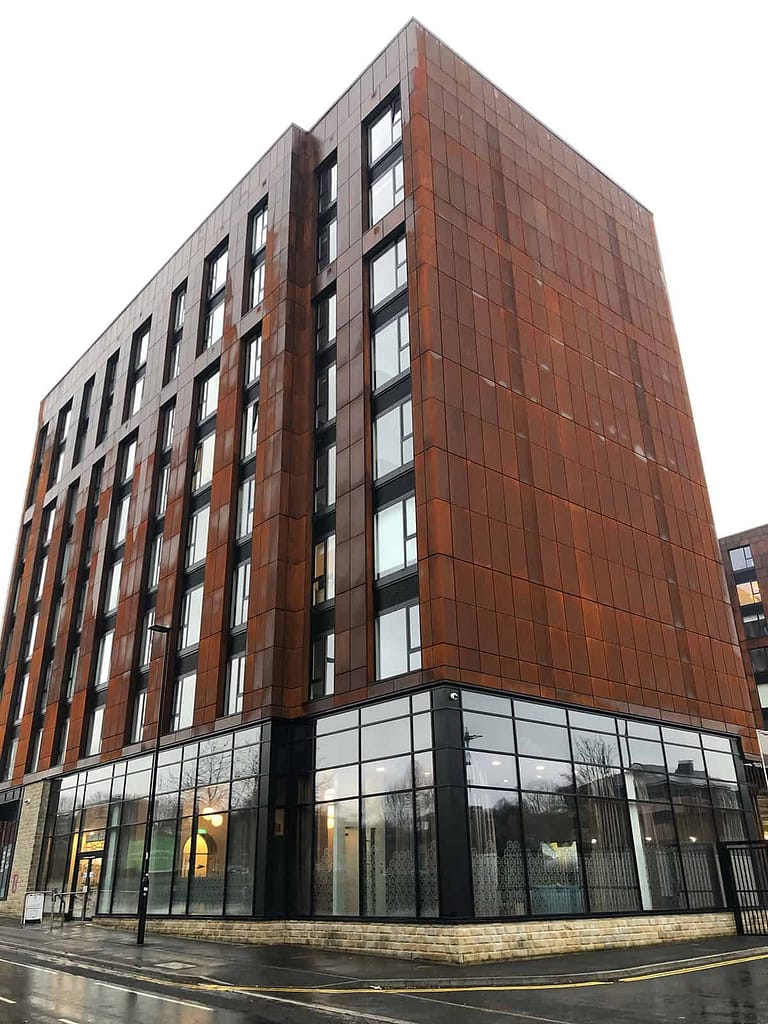 Exterior of Brook Place Apartments, Sheffield with its corten steel facade and glazing to the ground floor.